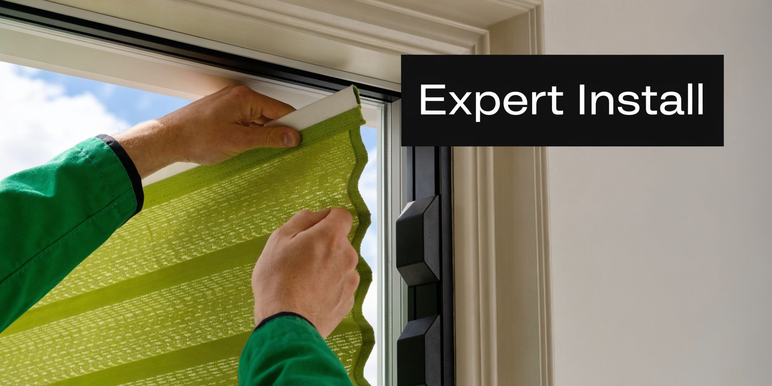 A professional technician carefully installing green honeycomb window blinds into a modern home window frame.