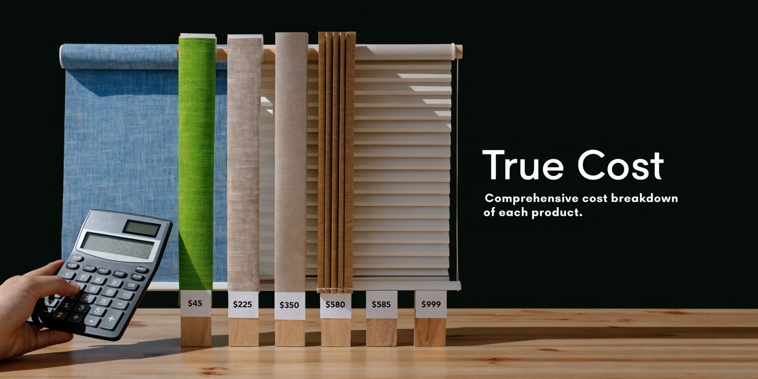 A hand holding a calculator next to fabric window blind samples showing individual price tags for reference.